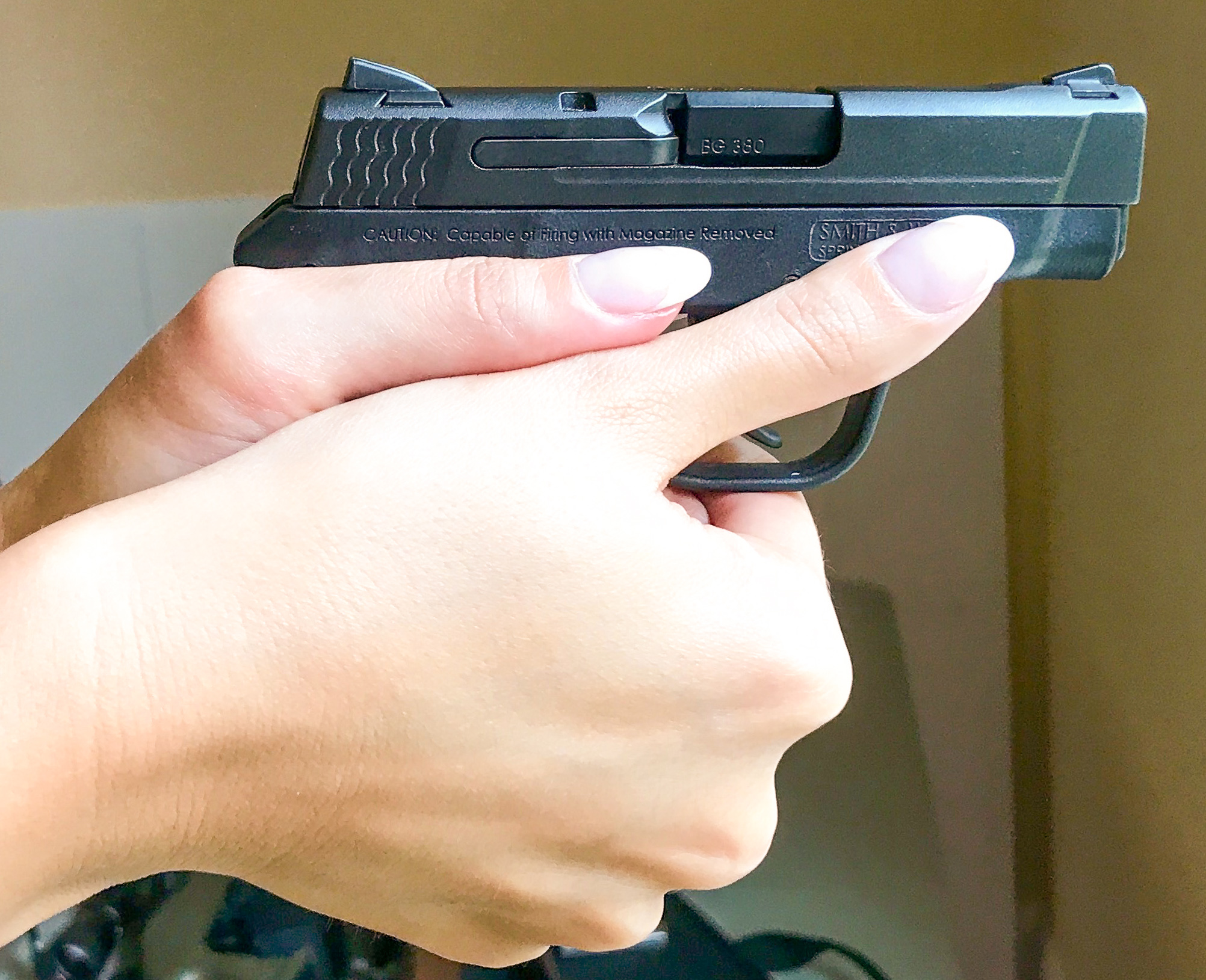 Support side view of two-handed grip on small pistol by large left-handed shooter