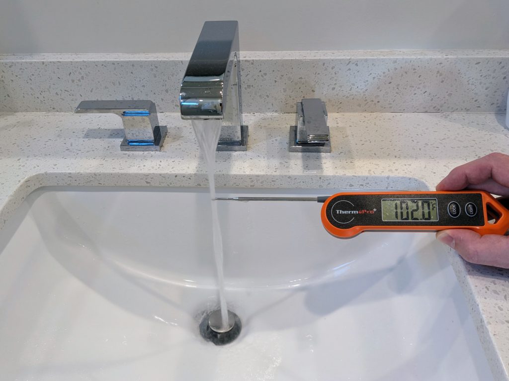 Thermometer showing cold tap water measuring 102°F